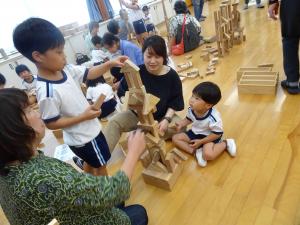 子どもと、おばあちゃんが積み木で遊ぶ写真