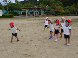 広場でだるまさんがころんだをして遊んでいるところ