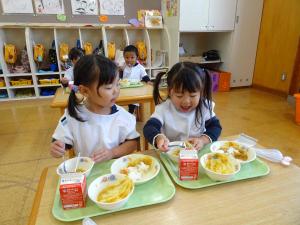女の子が給食を食べている写真