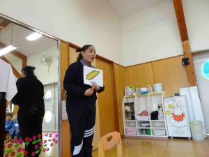 英語の先生がトウモロコシのイラストをもっている写真