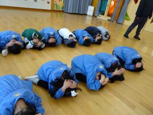 子ども達が頭を守って低い姿勢になっている写真