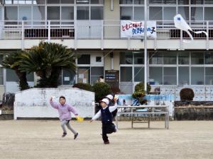 小学校の校庭で凧揚げをしている写真