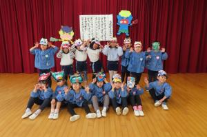 手作りの鬼のお面をつけて集合写真を撮っているところ