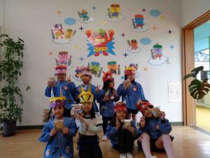 子ども達がお菓子をもってポーズを決める集合写真