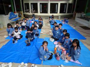 ブルーシートを広げて子ども達が座っている写真