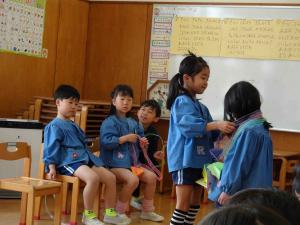 女の子が首飾りを首にかけている写真