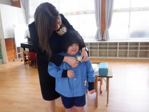 5歳児が花をつけてもらっているところ