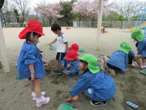 5歳児が3歳児に優しく話しかけている様子