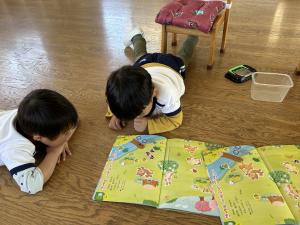 新入園児が絵本を見ている写真