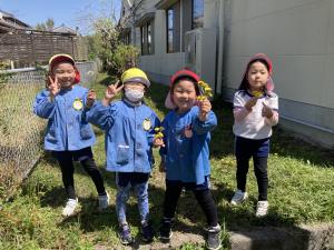 見つけたたんぽぽや綿毛を持ってポーズを取る写真
