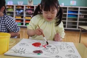 描いたてんとう虫に絵の具で塗っている写真