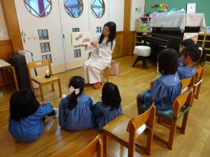4歳児が集まって絵本を読んでもらっているところ