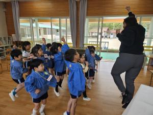先生と英語の歌で踊っている写真