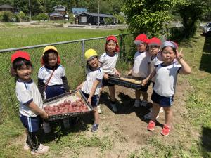 採ったジャガイモを持ってニコニコ笑顔な写真
