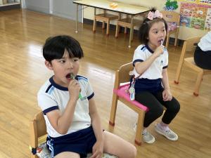 歯科衛生士の方から歯の磨き方を教えてもらいきれいに磨いている写真