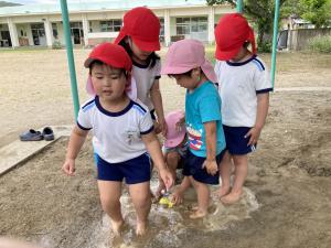 泥の温泉に足を入れて遊んでいる写真