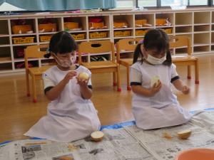 ３歳児が玉ねぎの皮むきをしている様子