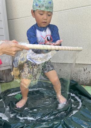 大きなシャボン玉を楽しむ3歳児の写真