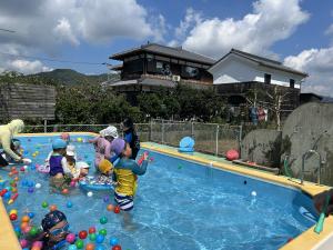 飛んでいるシャボン玉を水鉄砲で撃って遊んでいる写真