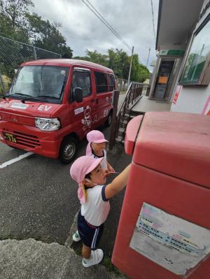 はがきをポストに投函している写真